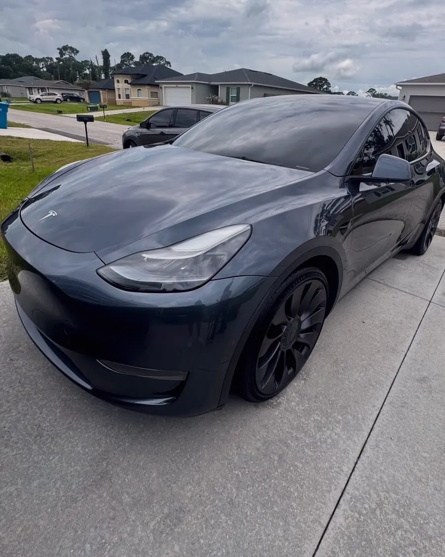 A gray Tesla Model Y detailed in a driveway