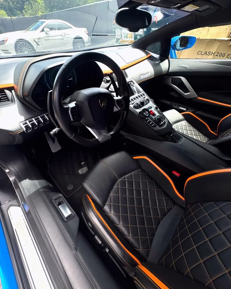 A Lamborghini interior with orange diamond stitched seats, detailed by GaliGloss