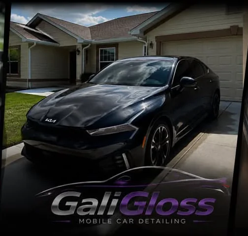 A glossy black Kia K5 in the driveway after the detail